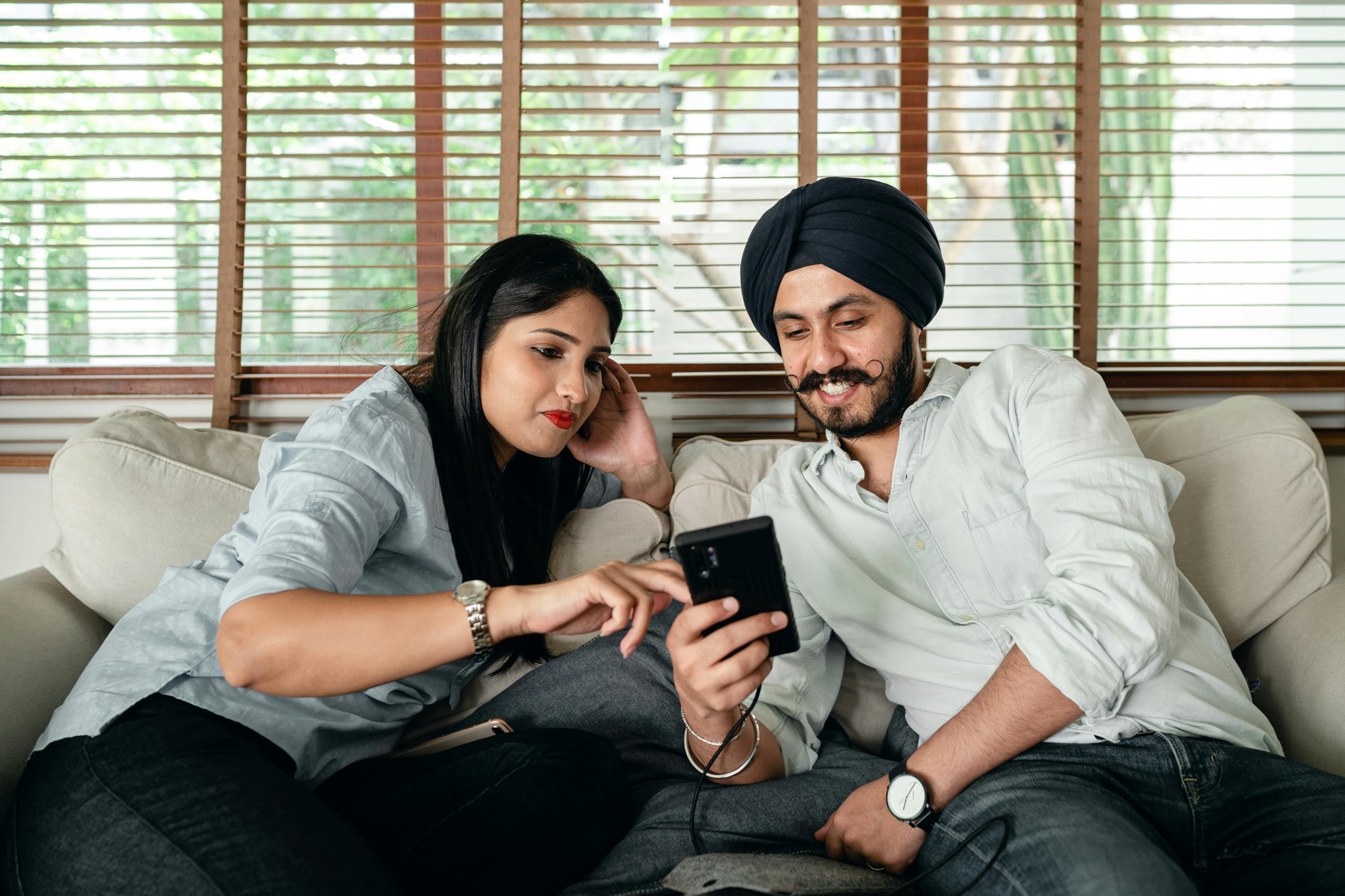 Indian couple using a smartphone together while reviewing information